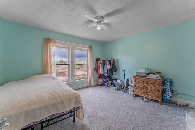 bedroom with carpet, a textured ceiling, and ceiling fan