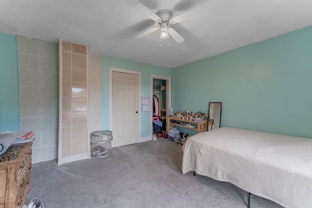 carpeted bedroom with a textured ceiling, a closet, and ceiling fan