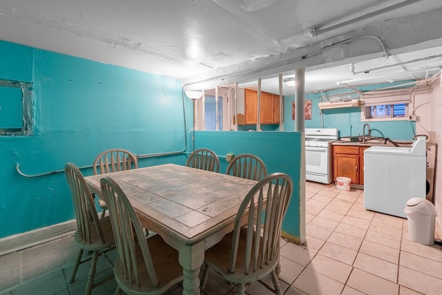 dining room featuring washer / dryer, sink, and light tile patterned floors