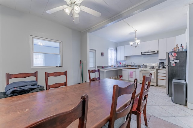 tiled dining area with sink and ceiling fan with notable chandelier