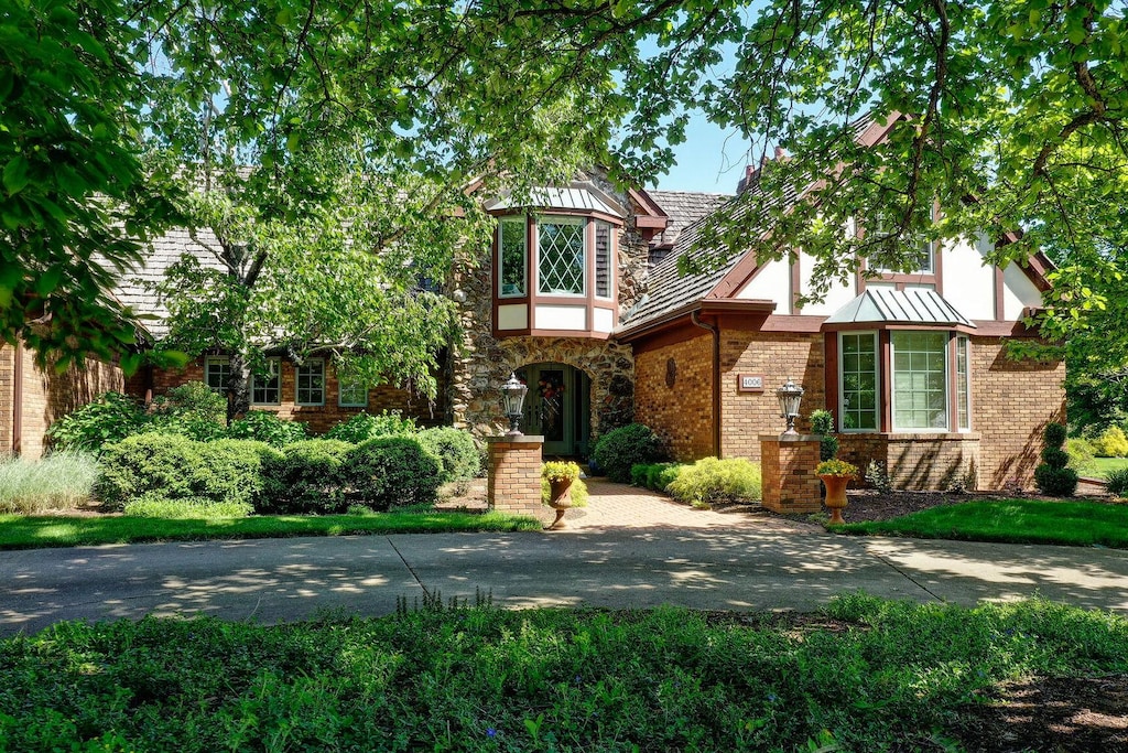 4006 Lakepoint Rd, Champaign, IL 61822 - tudor home with stucco siding, a standing seam roof, and brick siding