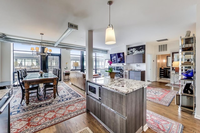 kitchen with light wood-style flooring, modern cabinets, a kitchen island, and visible vents