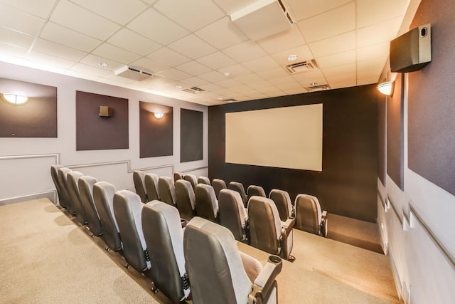 cinema with carpet floors, visible vents, and a paneled ceiling