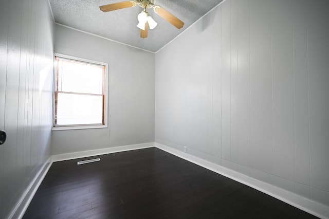 spare room with ceiling fan, dark hardwood / wood-style flooring, and a textured ceiling