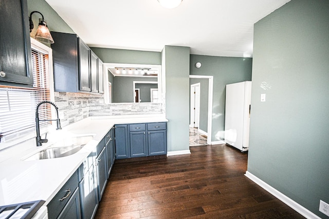 kitchen featuring dark hardwood / wood-style flooring, sink, tasteful backsplash, and white refrigerator