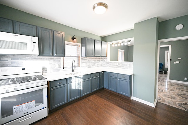 kitchen featuring white appliances, dark hardwood / wood-style flooring, sink, and decorative backsplash