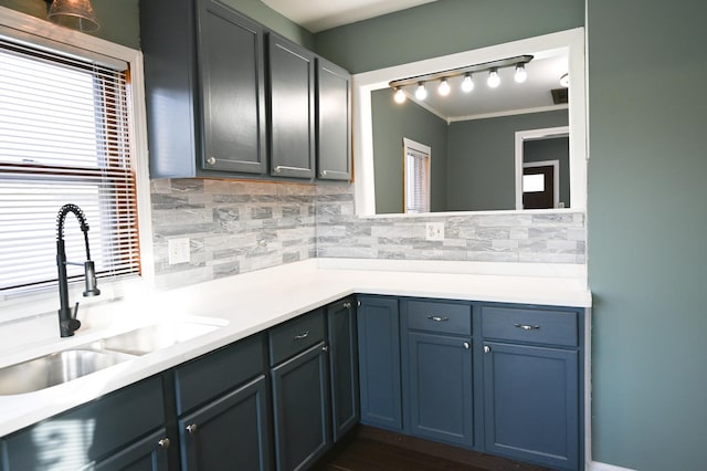 kitchen with crown molding, sink, and backsplash