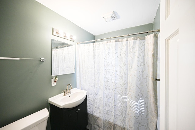 bathroom with vanity, a shower with shower curtain, and toilet