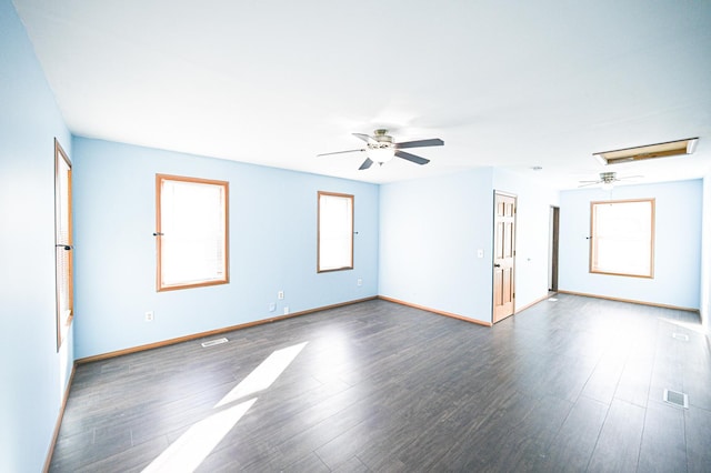 spare room with dark wood-type flooring, ceiling fan, and plenty of natural light