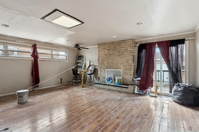 interior space with crown molding, hardwood / wood-style floors, ceiling fan, and a fireplace