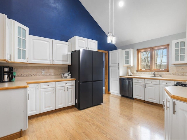 kitchen with glass insert cabinets, freestanding refrigerator, light wood-style floors, white cabinets, and dishwashing machine