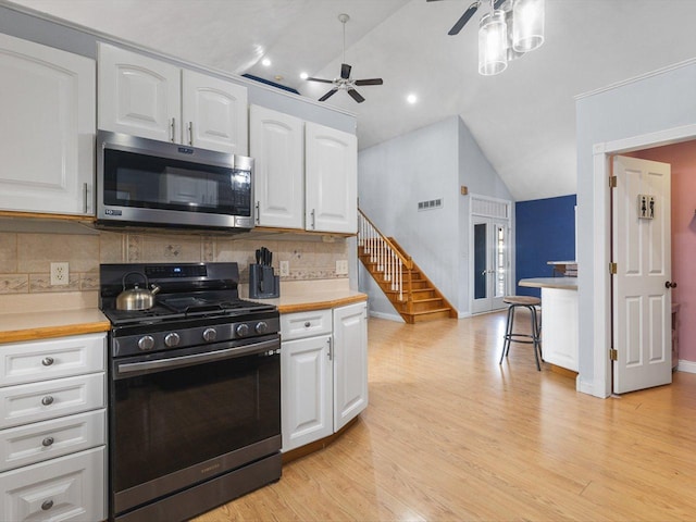 kitchen with visible vents, light countertops, lofted ceiling, appliances with stainless steel finishes, and white cabinets