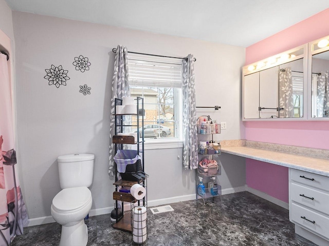 bathroom with vanity, toilet, visible vents, and baseboards