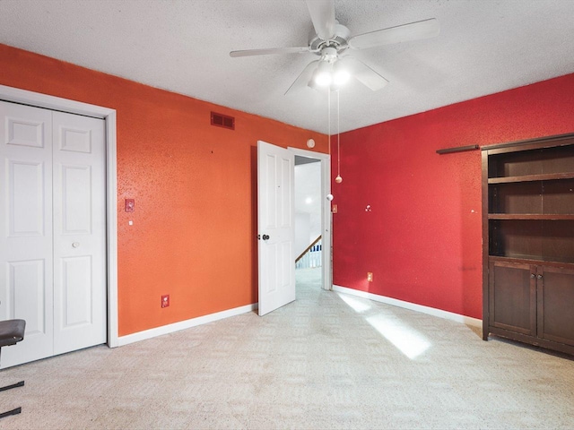 unfurnished bedroom with baseboards, visible vents, carpet floors, and a textured ceiling