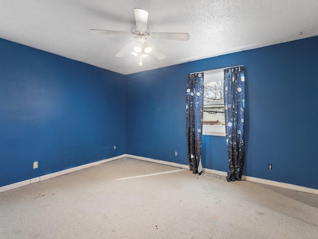 empty room featuring visible vents, baseboards, carpet flooring, a textured ceiling, and a ceiling fan