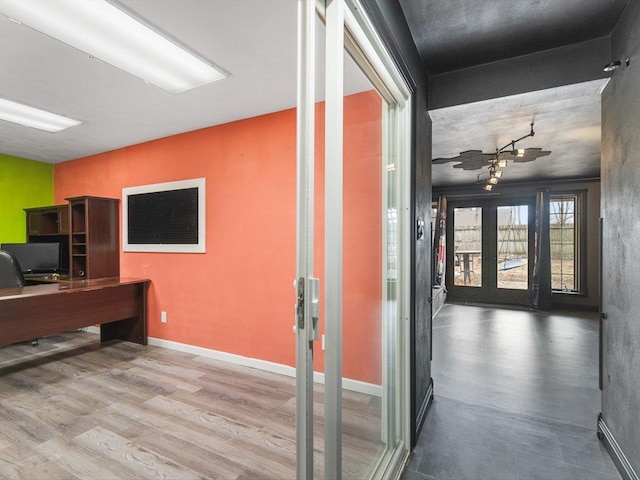 home office with french doors, baseboards, and wood finished floors