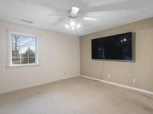 carpeted spare room with baseboards, visible vents, and ceiling fan