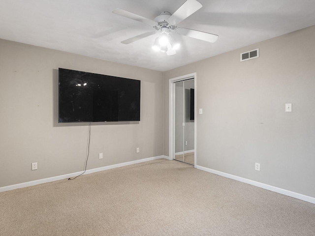 spare room featuring baseboards, visible vents, carpet floors, and ceiling fan