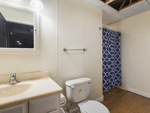 bathroom with toilet, wood finished floors, a shower with shower curtain, baseboards, and vanity