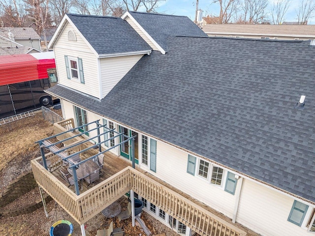 exterior space featuring stairway and roof with shingles