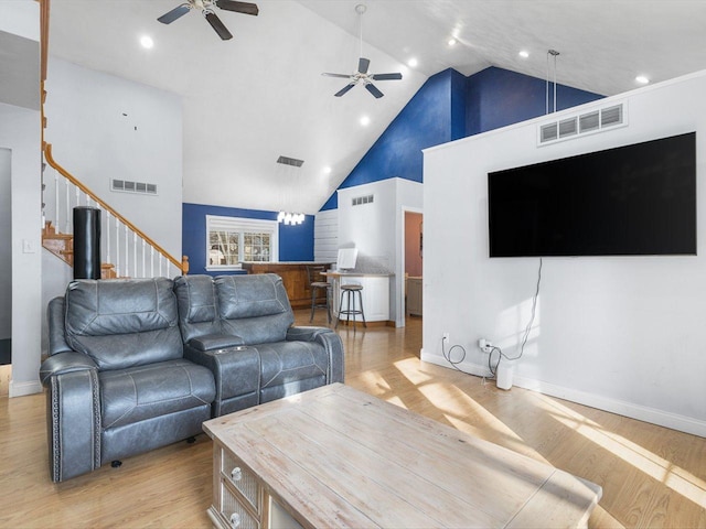 living area featuring visible vents, high vaulted ceiling, and light wood-type flooring