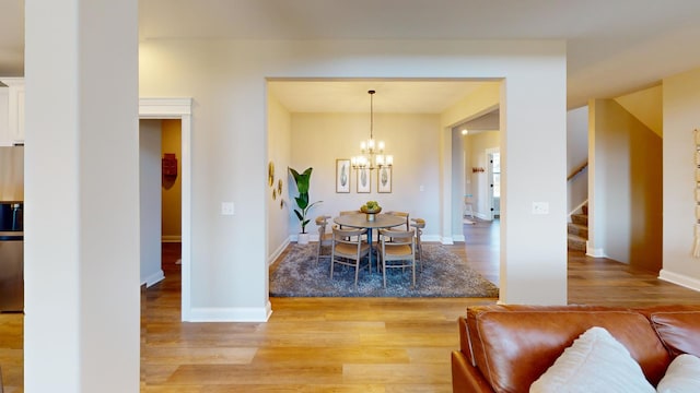 dining space featuring an inviting chandelier and light wood-type flooring