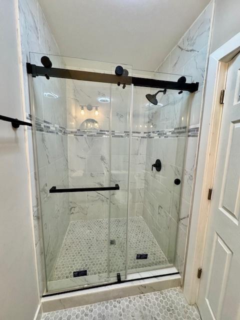 bathroom with a shower with door