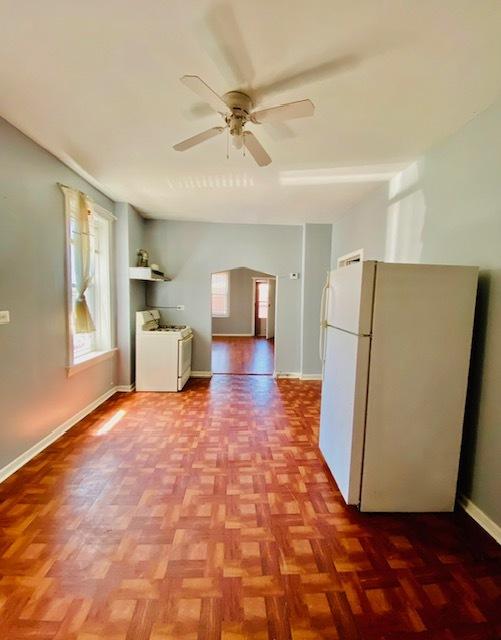 kitchen featuring light parquet floors, ceiling fan, and white appliances