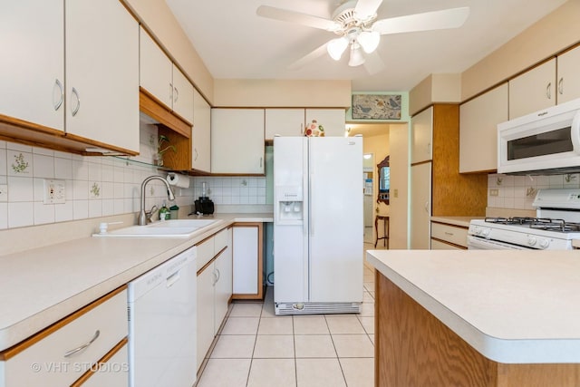 kitchen with sink, white cabinets, decorative backsplash, light tile patterned floors, and white appliances