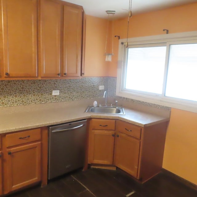 kitchen with dark wood-type flooring, sink, tasteful backsplash, decorative light fixtures, and dishwasher