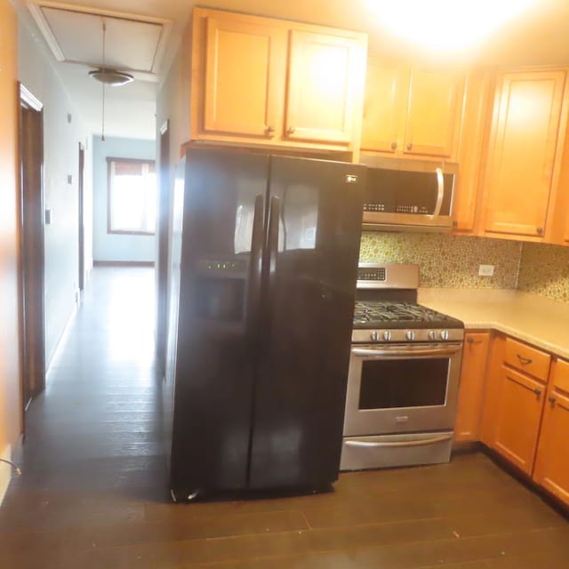 kitchen featuring stainless steel appliances, dark hardwood / wood-style floors, and decorative backsplash