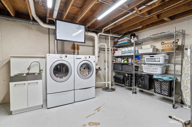 washroom with washer and dryer, laundry area, and a sink