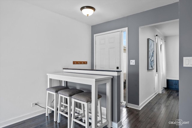 dining room featuring dark wood finished floors and baseboards