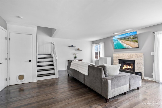 living room with stairs, a fireplace, baseboards, and wood-type flooring