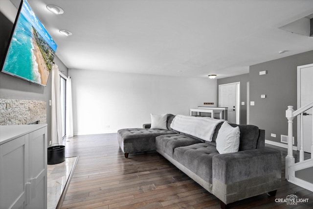 living room featuring visible vents, stairs, baseboards, and hardwood / wood-style floors