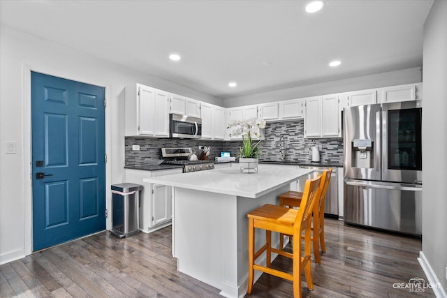 kitchen featuring dark wood finished floors, white cabinetry, and appliances with stainless steel finishes