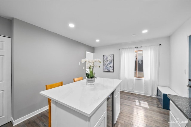 kitchen with recessed lighting, baseboards, dark wood-style floors, and a center island