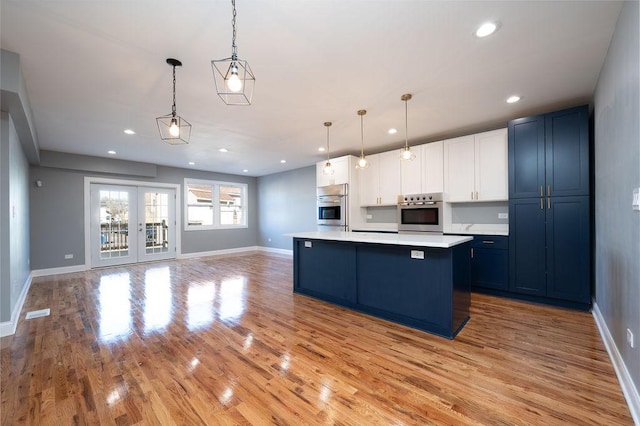 kitchen featuring blue cabinetry, oven, and decorative light fixtures