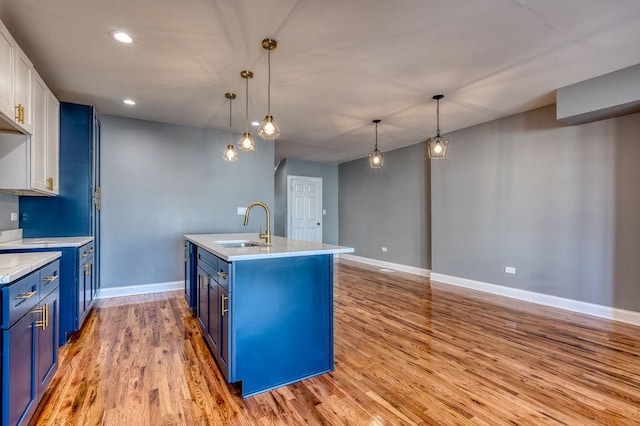 kitchen with sink, decorative light fixtures, blue cabinetry, and white cabinets