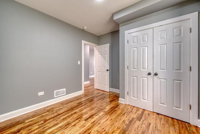 unfurnished bedroom with light hardwood / wood-style floors and a closet