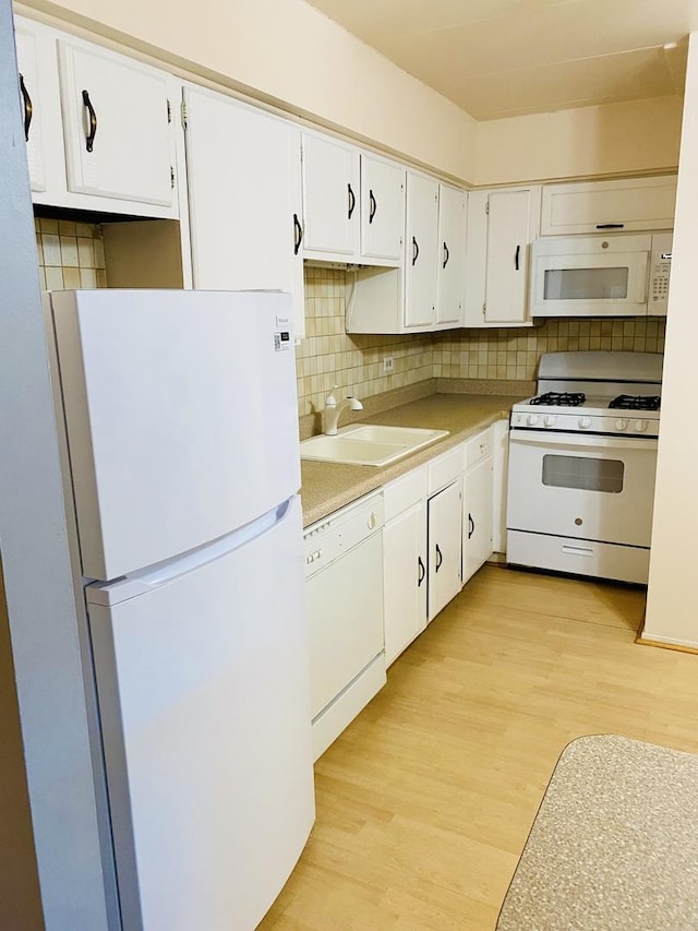 kitchen featuring white cabinetry, sink, white appliances, and light hardwood / wood-style floors