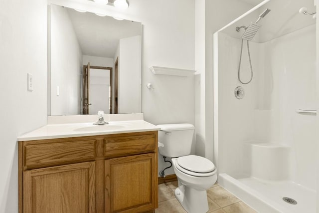 bathroom featuring tile patterned floors, toilet, vanity, and a shower