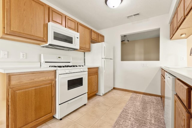 kitchen with white appliances, sink, and light tile patterned floors