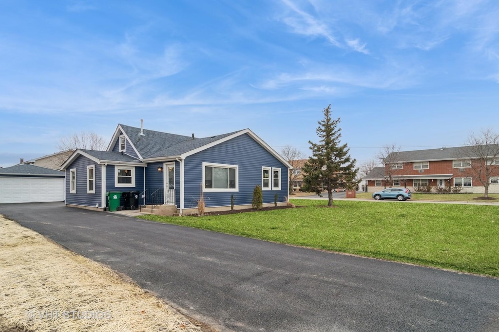 single story home with a garage, an outdoor structure, and a front lawn