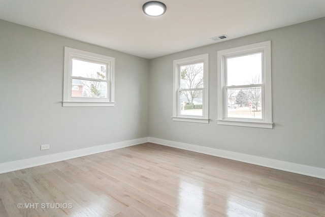 unfurnished room featuring light hardwood / wood-style floors and a wealth of natural light