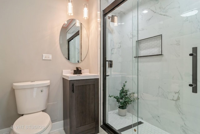 bathroom with vanity, a shower with shower door, and toilet