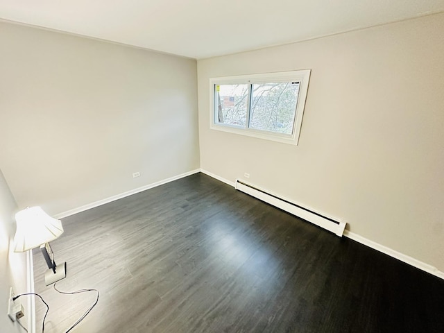 spare room featuring a baseboard radiator and dark wood-type flooring