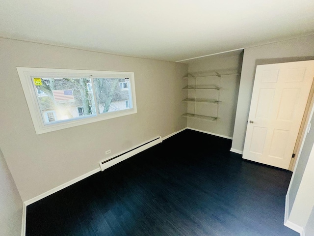 unfurnished bedroom featuring dark hardwood / wood-style flooring and baseboard heating