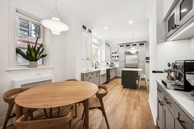 kitchen with appliances with stainless steel finishes, a center island, hanging light fixtures, and gray cabinetry