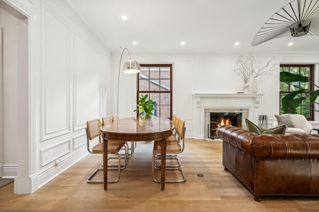 dining area featuring plenty of natural light, a high end fireplace, and light hardwood / wood-style floors